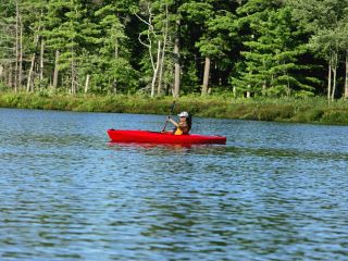 Solo woman kayaking on the lake in summer at The Lodge at Woodloch