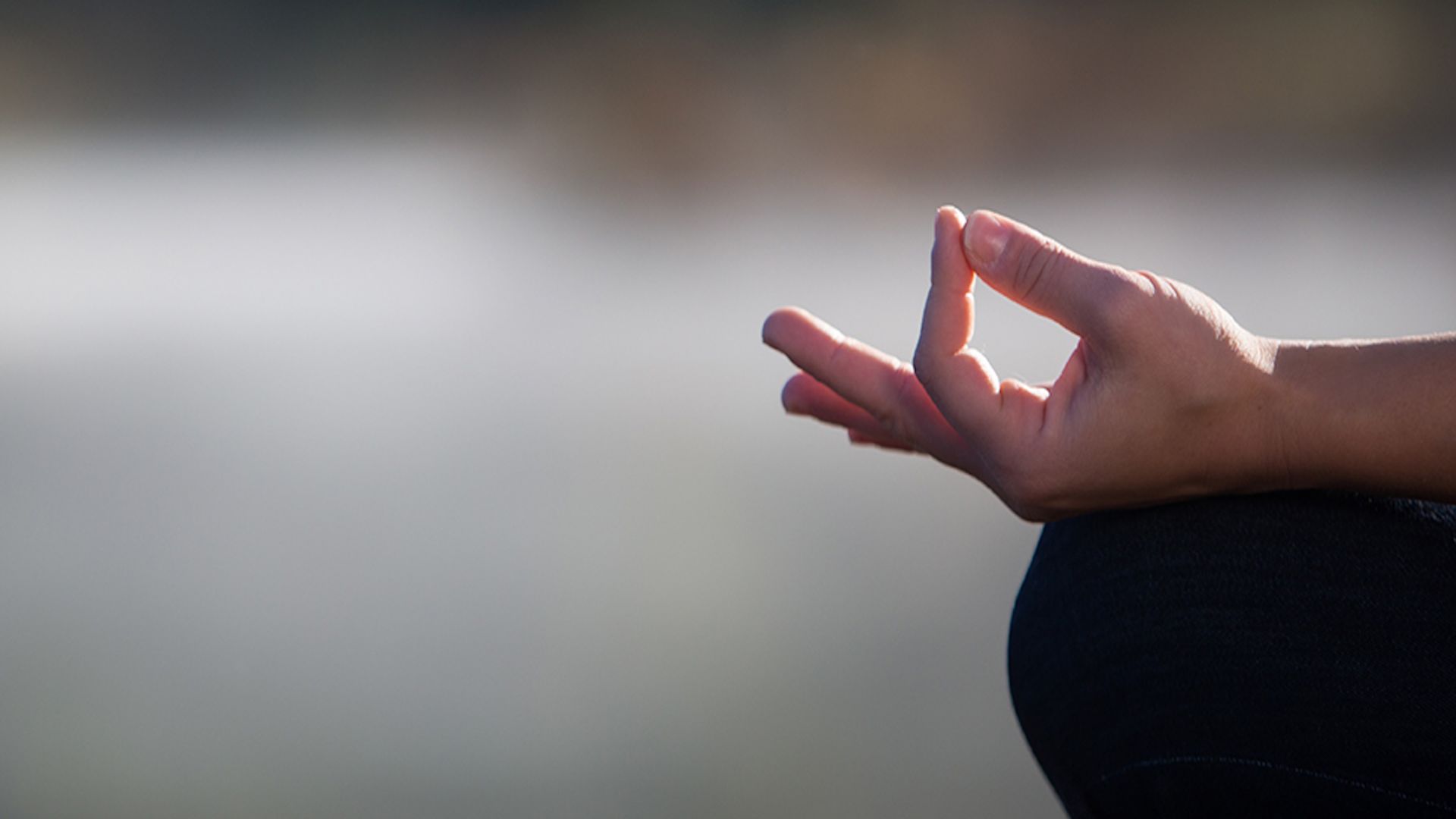 A close up of a person's hands as they are in a meditation pose