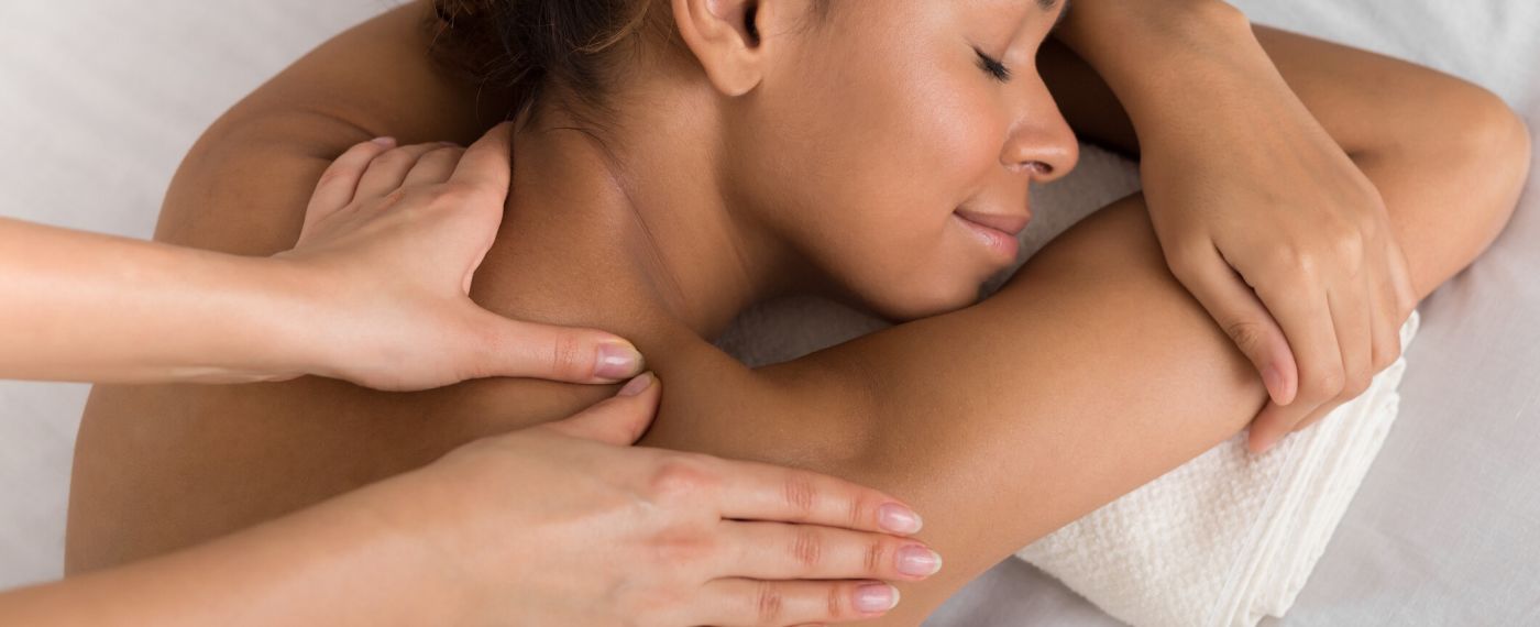A close up of a woman getting a massage on her shoulders