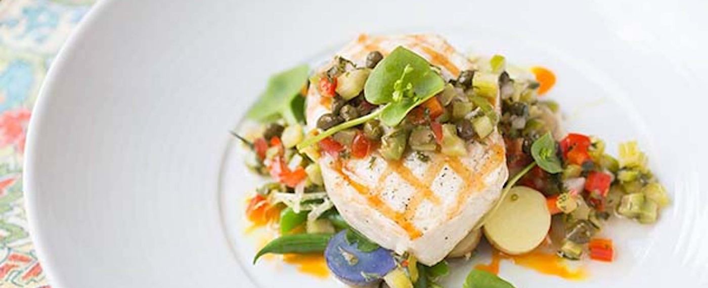 Grilled Swordfish Nicoise on a White Plate on a colorful placemat