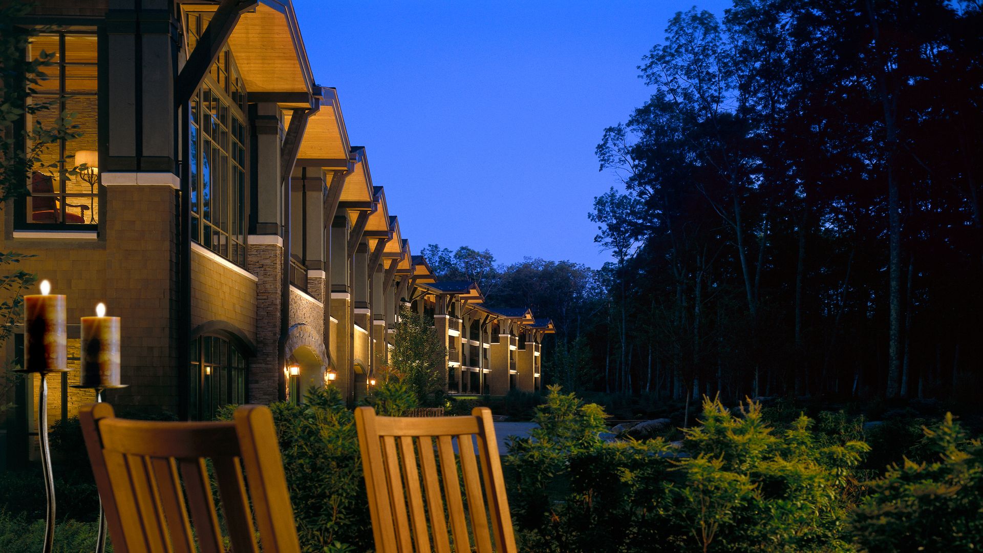 The back exterior view of The Lodge at Woodloch at dusk in the summer