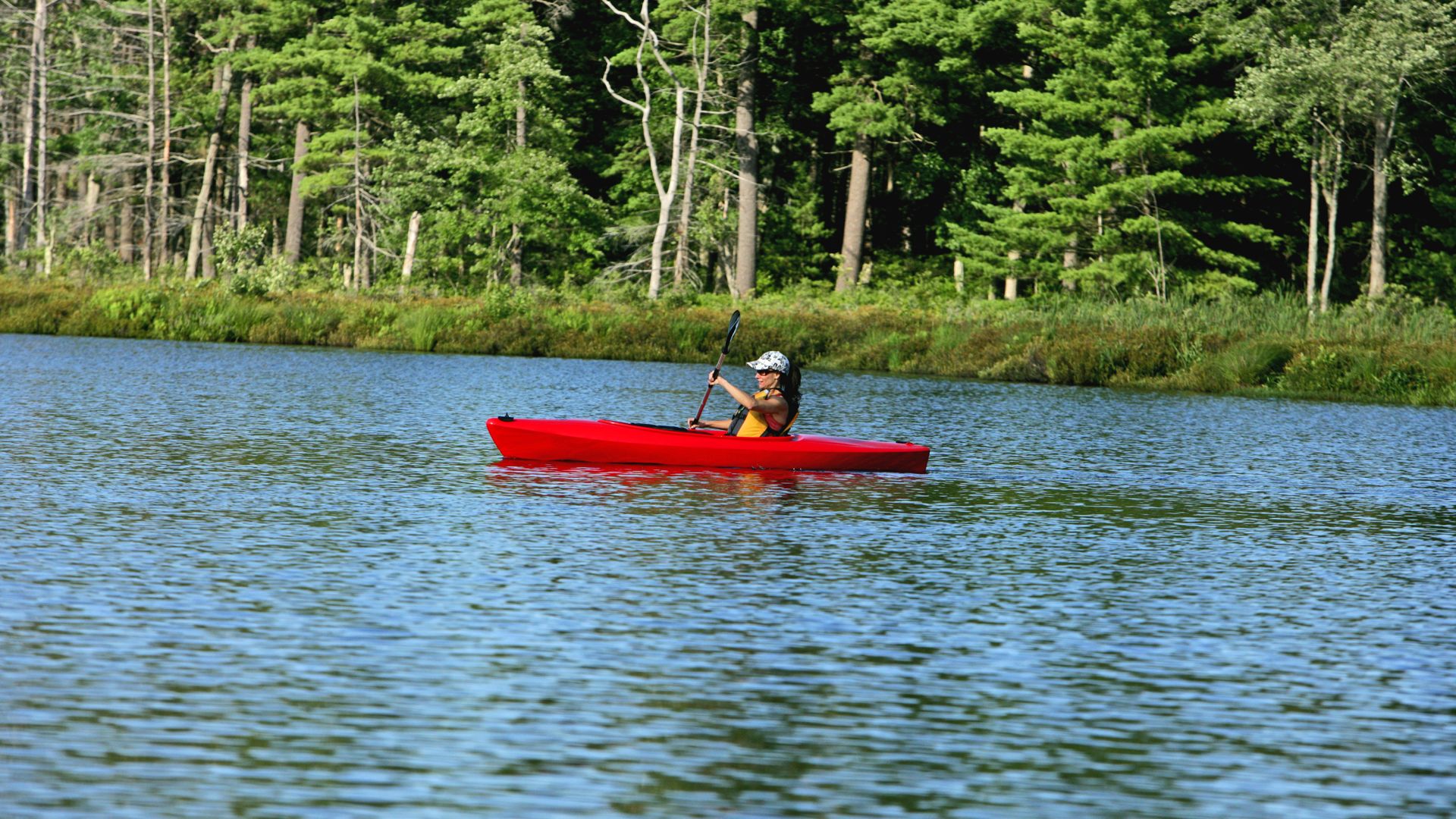 Solo woman kayaking on the lake in summer at The Lodge at Woodloch